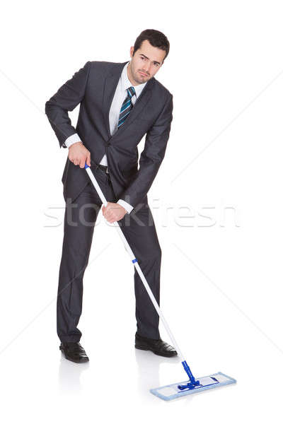 Businessman cleaning floor Stock photo © AndreyPopov