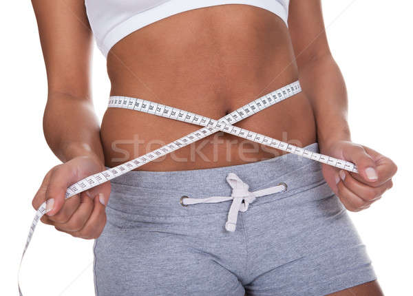 Portrait Of Young Woman Measuring Her Waistline Stock photo © AndreyPopov