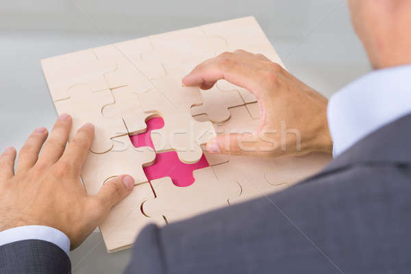 Businessman assembling jigsaw puzzle Stock photo © AndreyPopov