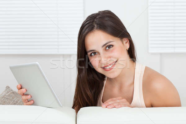 Beautiful Woman Holding Digital Tablet On Sofa Stock photo © AndreyPopov