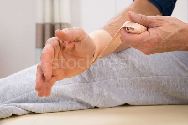 Man Tying Bandage To His Wrist Stock photo © AndreyPopov