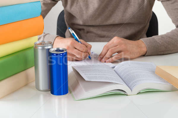 Male Student Writing In Book At Table Stock photo © AndreyPopov