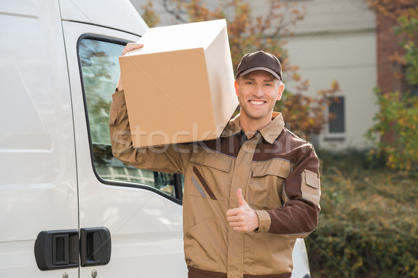 Delivery Man Carrying Cardboard Box On Shoulder Stock photo © AndreyPopov