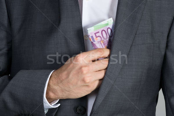 Businessman Putting Bribe In Suit Pocket Stock photo © AndreyPopov