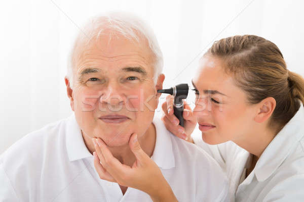 Doctor Looking At Patient's Ear Through Otoscope Stock photo © AndreyPopov