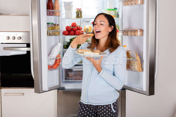 Kadın yeme tatlı gıda buzdolabı genç kadın tadını çıkarmak Stok fotoğraf © AndreyPopov