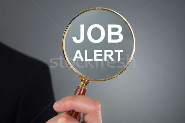 Person Holding Magnifying Glass With Text Job Alert Stock photo © AndreyPopov