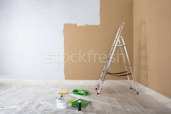 Half Painted White Wall With Ladder And Painting Equipments Stock photo © AndreyPopov
