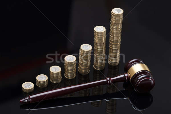 Gavel On Sounding Block In Front Of Stacked Coins Stock photo © AndreyPopov