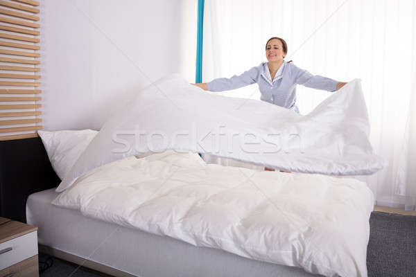 Stock foto: Haushälterin · Bett · lächelnd · jungen · weiblichen · Hotelzimmer