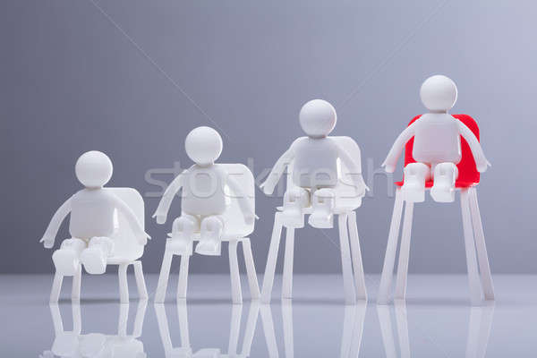 Close-up Of Human Figures Sitting On Increasing Chairs Stock photo © AndreyPopov