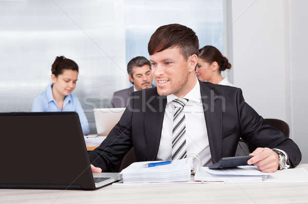 üzletember dolgozik iroda boldog ül kollégák Stock fotó © AndreyPopov