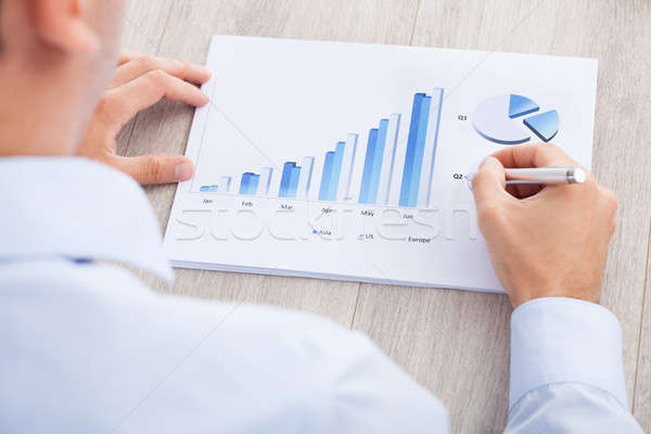 Businessman Analyzing Graph At Desk Stock photo © AndreyPopov
