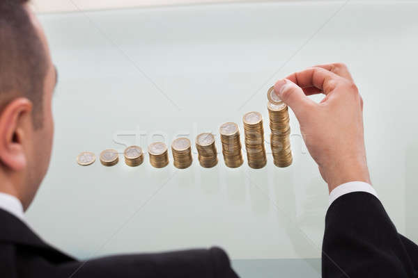 Businessman Stacking Coins In Increasing Order Stock photo © AndreyPopov