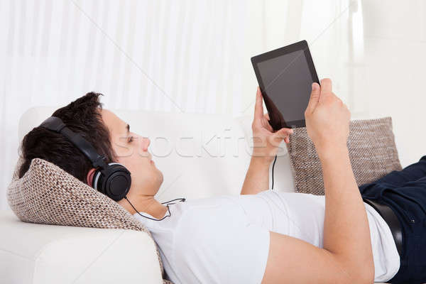 Man Listening To Music On Digital Tablet At Home Stock photo © AndreyPopov