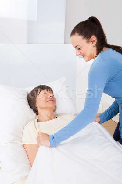 Caretaker Covering Senior Woman With Blanket Stock photo © AndreyPopov