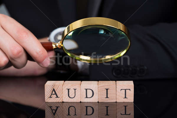 Businessman Examining Audit Blocks Through Magnifying Glass Stock photo © AndreyPopov