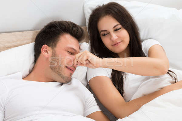 Woman Holding Husband's Nose While Sleeping Stock photo © AndreyPopov