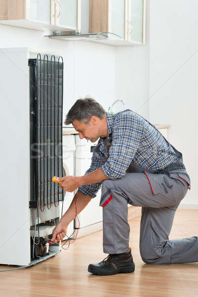 Technician Checking Fridge With Multimeter At Home Stock photo © AndreyPopov