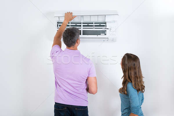 Pareja acondicionador de aire adjunto blanco pared trabajo Foto stock © AndreyPopov