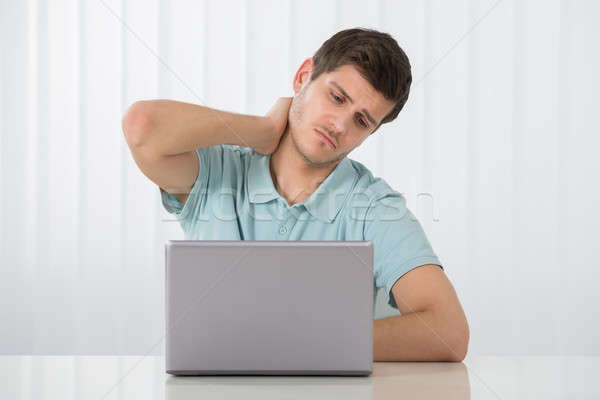 男子 頸部疼痛 年輕人 工作的 筆記本電腦 商業照片 © AndreyPopov