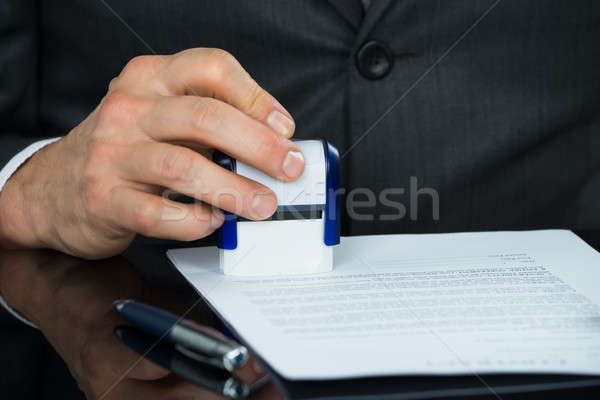 Close-up Of Businessman Stamping Document Stock photo © AndreyPopov