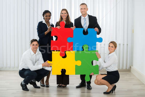 Businesspeople Holding Puzzle Pieces Stock photo © AndreyPopov