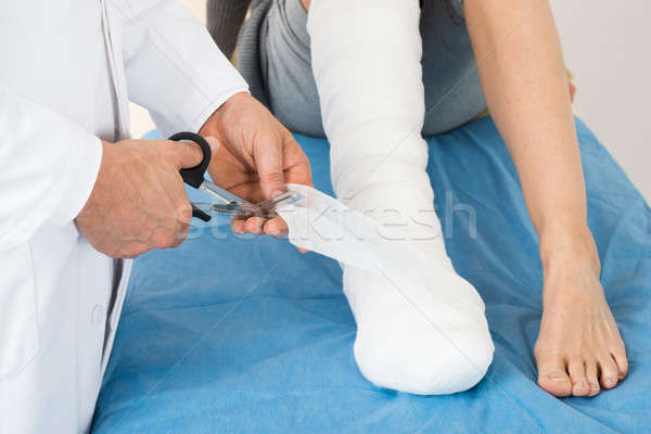 Doctor Bandaging Leg Of Patient Stock photo © AndreyPopov