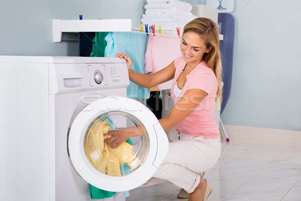 Mujer sonriente ropa lavadora jóvenes utilidad habitación Foto stock © AndreyPopov