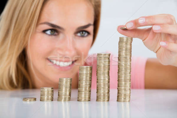 Happy Woman Inserting Coin On The Stacked Of Coins Stock photo © AndreyPopov