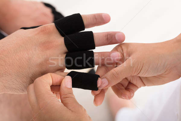 Doctor Putting Finger Protector Sleeve On Man's Finger Stock photo © AndreyPopov