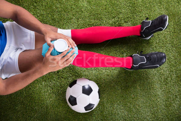 Stock photo: Injured Soccer Player Applying Ice Pack On Knee