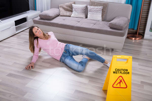 Stock photo: Woman Falling Near Caution Sign At Home