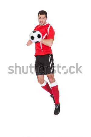 Stock photo: Professional soccer player kicking ball