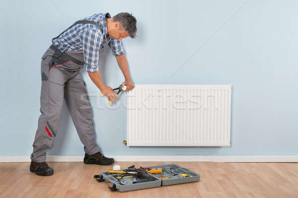 Male Plumber Repairing Radiator Stock photo © AndreyPopov