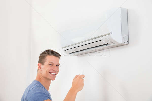Man With Remote Control To Operate Air Conditioner Stock photo © AndreyPopov