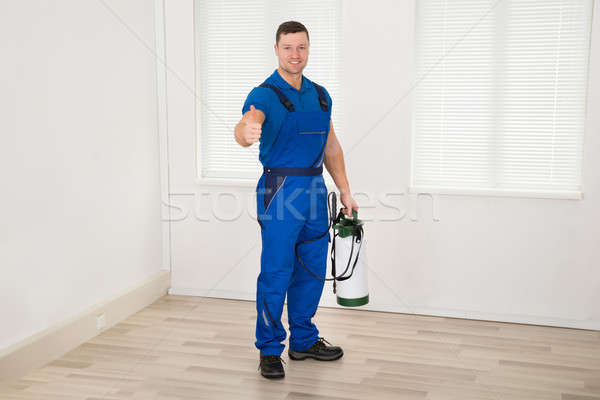 Smiling Male Worker Holding Pesticide Container At Home Stock photo © AndreyPopov