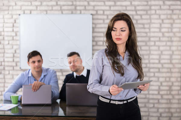 Businessmen Looking At Woman Holding Digital Tablet Stock photo © AndreyPopov