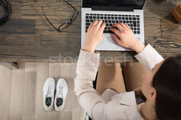 Sport Shoes Near The Businesswoman Using Laptop Stock photo © AndreyPopov