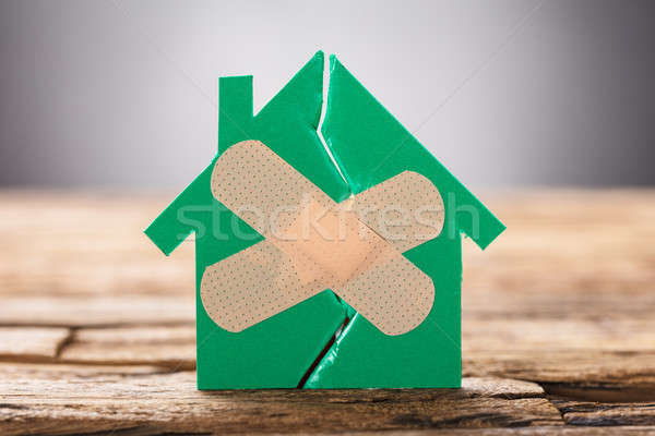 Closeup Of Broken House With Crossed Band Aid Stock photo © AndreyPopov