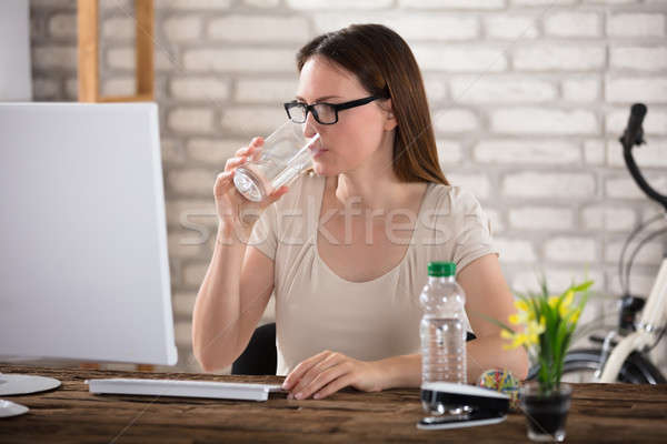 Woman Drinking Water While Using Computer Stock photo © AndreyPopov