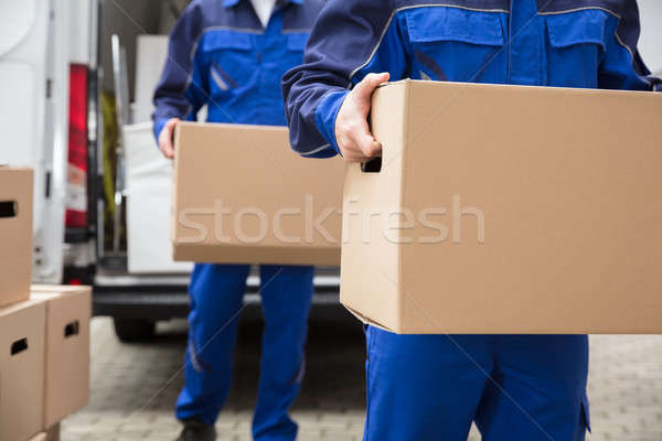 Close-up Of Two Movers Carrying Cardboard Box Stock photo © AndreyPopov