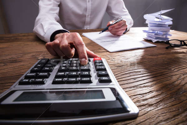 Businessperson Calculating Bill With Calculator Stock photo © AndreyPopov