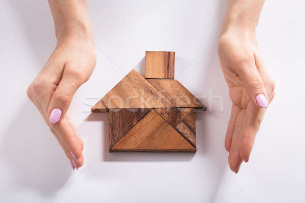 Woman Protecting House Made Of Wooden Tangram Puzzle Stock photo © AndreyPopov