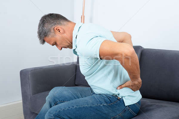 Hombre maduro sufrimiento dolor de espalda sesión sofá hombres Foto stock © AndreyPopov