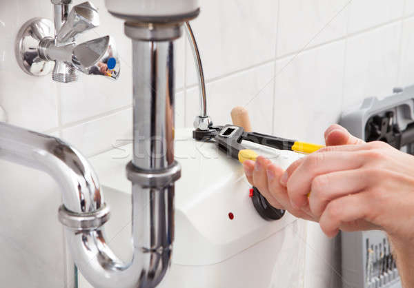 Fiatal vízvezetékszerelő megjavít mosdókagyló fürdőszoba portré Stock fotó © AndreyPopov