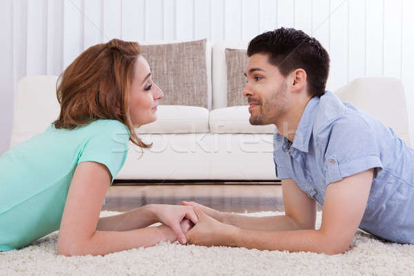 Happy young couple lying on front over carpet Stock photo © AndreyPopov