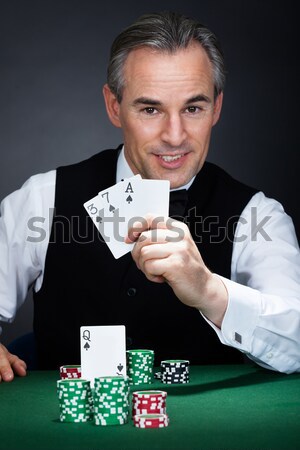 Portrait of a croupier aiming with a gun Stock photo © AndreyPopov