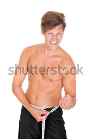 Young Man Measuring Waistline Stock photo © AndreyPopov