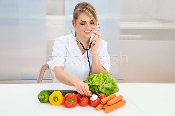 Female Dietician Examining Vegetables Stock photo © AndreyPopov